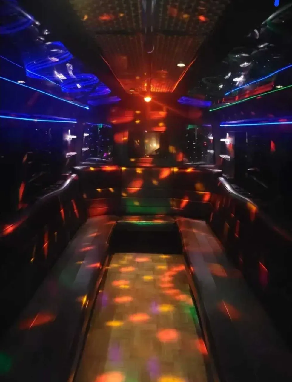 Black Party Bus interior with perimeter lounge seating and LED accent lighting, photo 2 for party bus rental