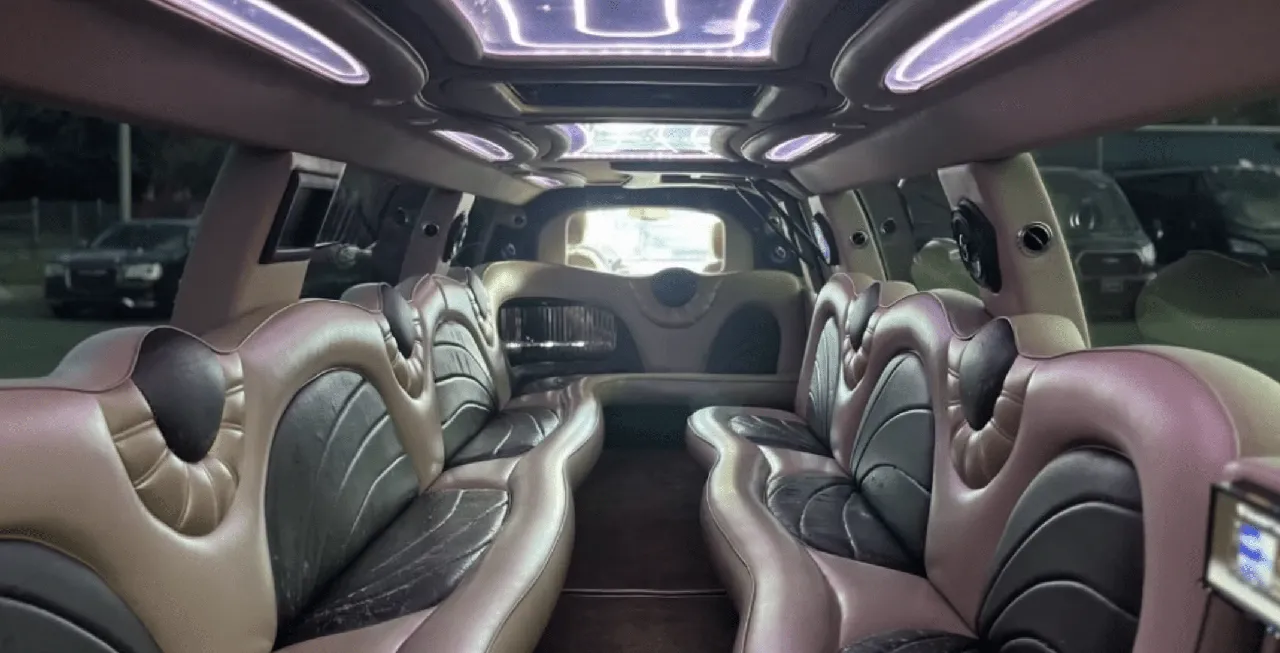 Cadillac Escalade Limo interior with perimeter lounge seating and LED ceiling lighting for limo rental