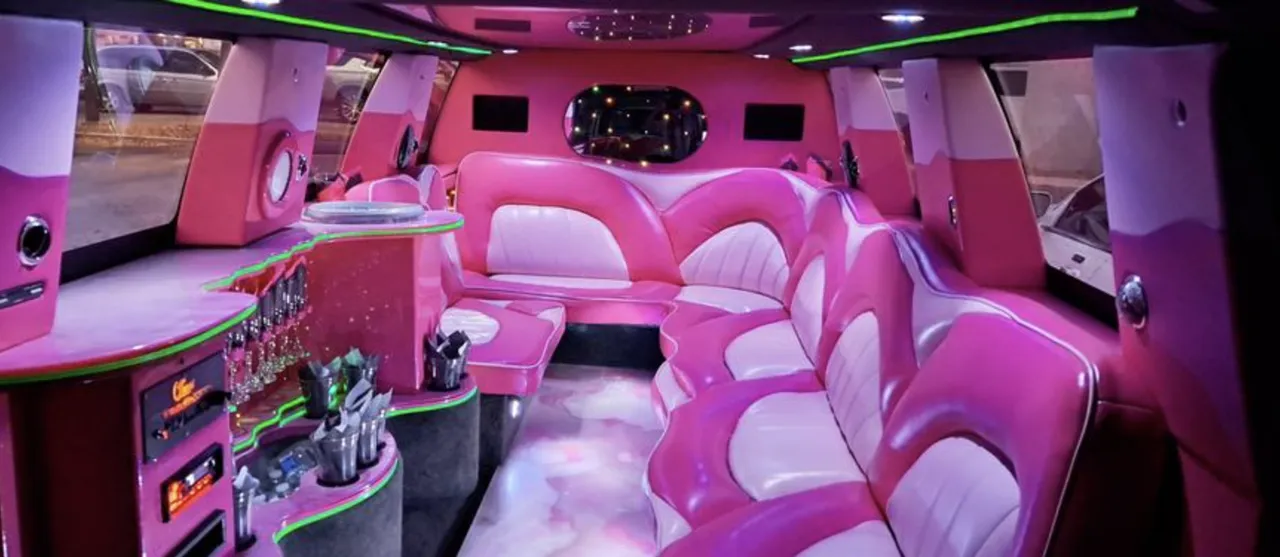 Chevrolet Suburban Limousine interior with sofa-style seating, LED accent lighting and bar area for limo rental
