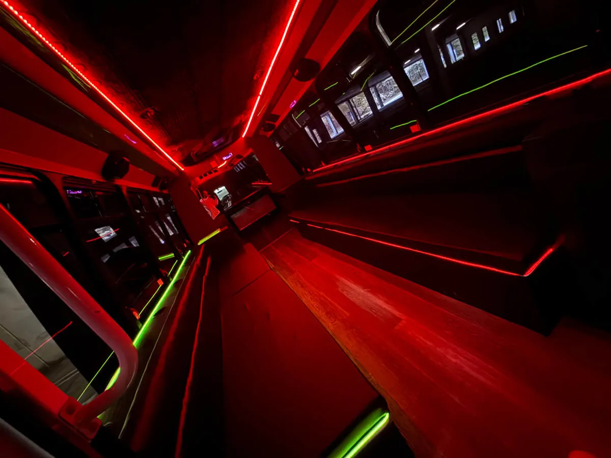 Ford E-450 Series Party BUS interior with perimeter lounge seating, LED accent lighting and LED ceiling lighting for party bus rental