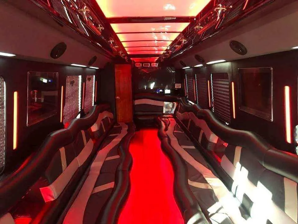 32 Passenger Limo Bus interior with perimeter lounge seating, LED accent lighting and LED ceiling lighting for party bus rental