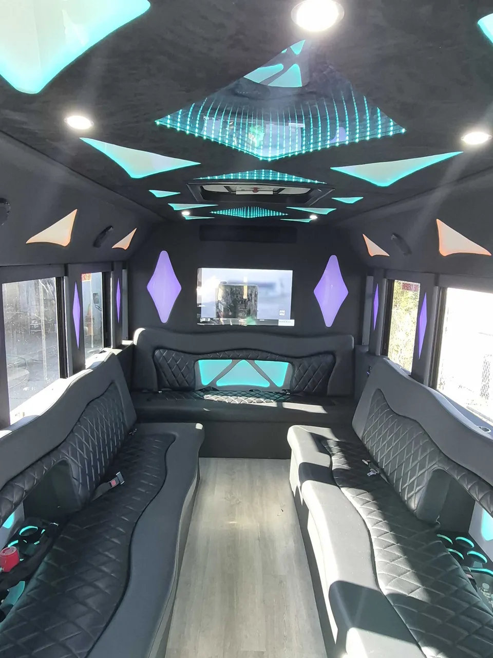 32 Passenger Limo Bus interior with perimeter lounge seating, LED accent lighting and LED ceiling lighting, photo 3 for party bus rental
