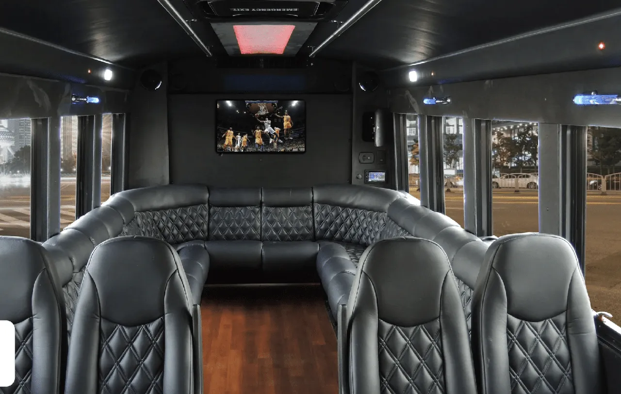 22 Passenger Limo Coach interior with perimeter lounge seating, sofa-style seating and wood-look flooring for party bus rental