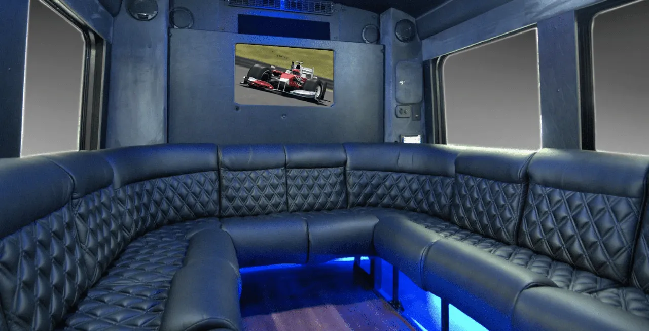 22 Passenger Limo Coach interior with perimeter lounge seating, sofa-style seating and LED accent lighting for party bus rental