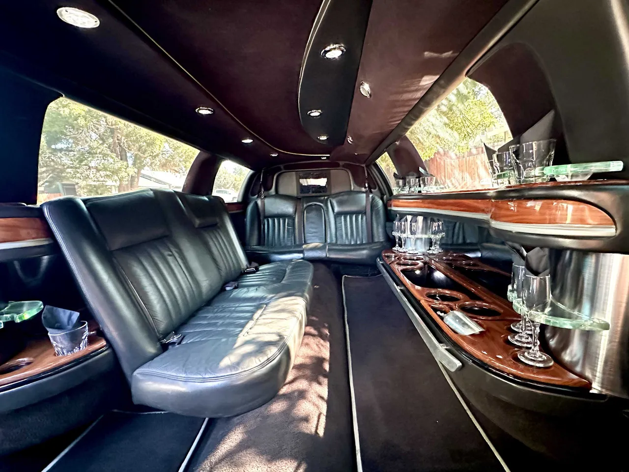Lincoln Towncar Limo interior with perimeter lounge seating, cup holders and bar area, photo 4 for limo rental