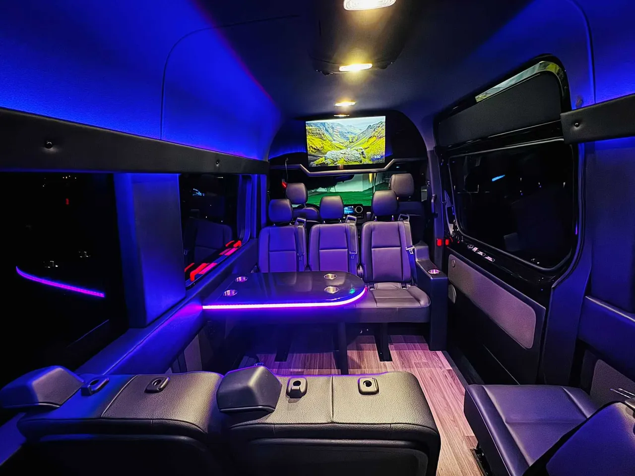 Mercedes Executive Sprinter interior with passenger tables, LED accent lighting and wood-look flooring, photo 2 for party bus rental