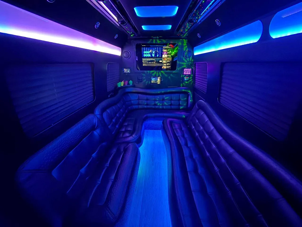 Mercedes Limo Sprinter interior with perimeter lounge seating, window shades and LED accent lighting for party bus rental