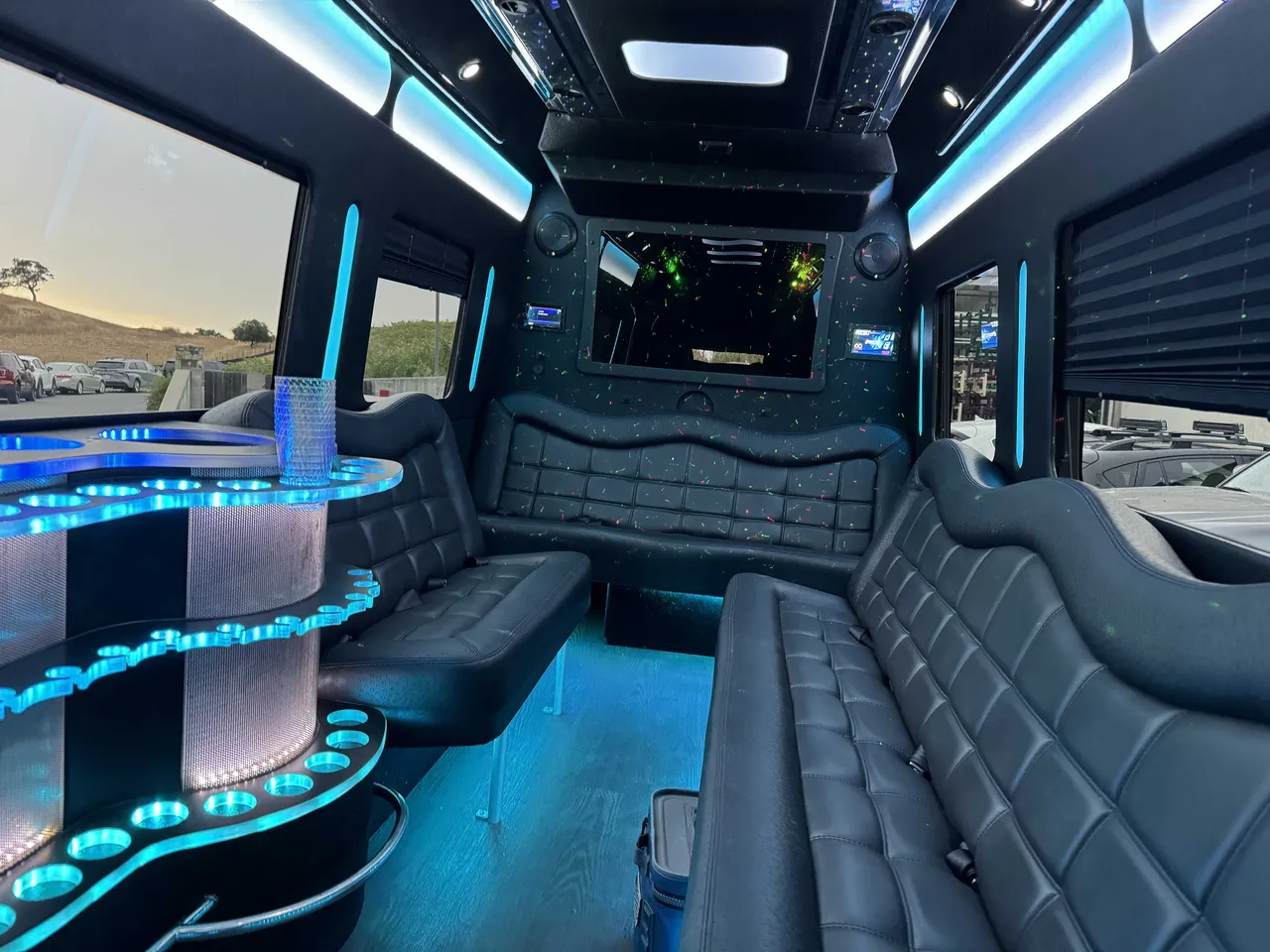 Mercedes Party Bus interior with perimeter lounge seating, window shades and LED accent lighting for party bus rental