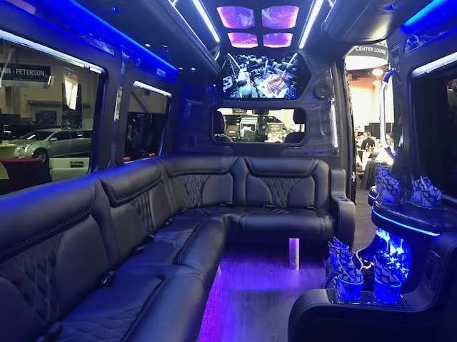 Mercedes Party Bus interior with sofa-style seating, LED accent lighting and LED ceiling lighting for party bus rental