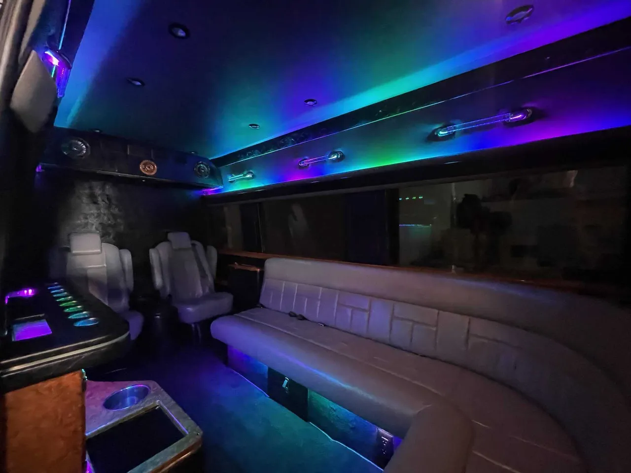 Mercedes Sprinter Limo interior with sofa-style seating, captain's chairs and LED accent lighting, photo 2 for party bus rental