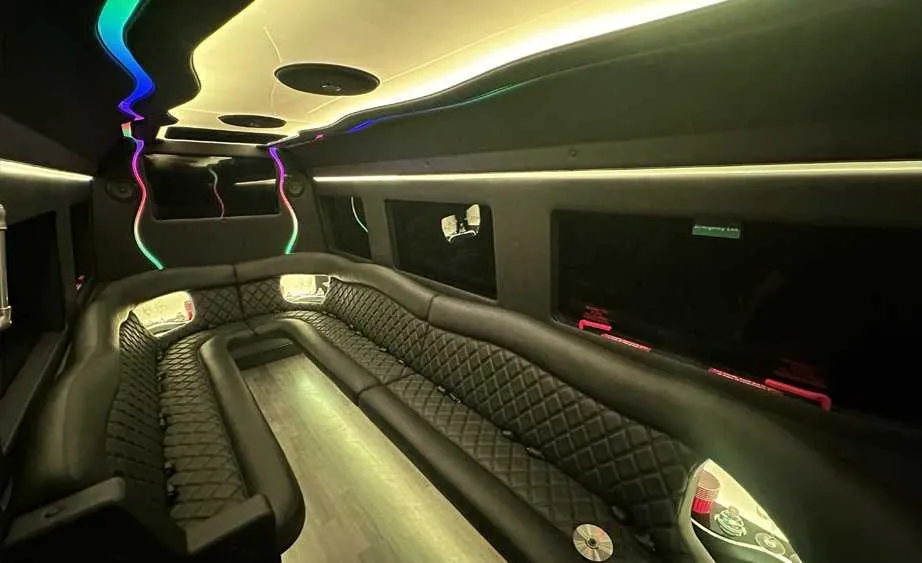 Mercedes Sprinter Limo interior with perimeter lounge seating, LED accent lighting and bar area for party bus rental