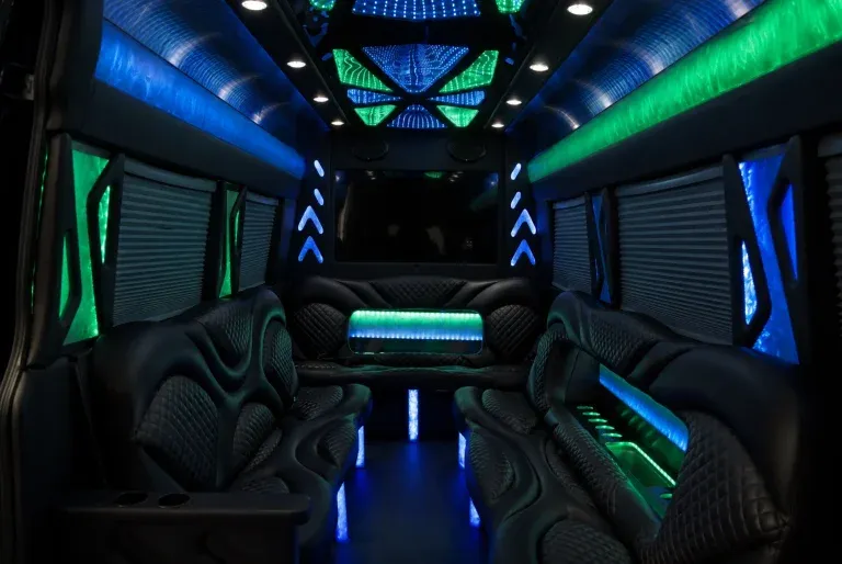 Mercedes Sprinter Limousine interior with perimeter lounge seating, window shades and LED accent lighting for party bus rental