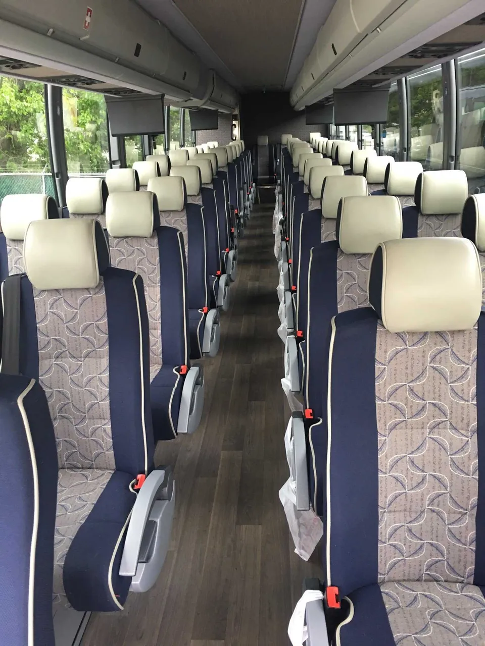 55 Passenger Motor Coach interior with overhead parcel racks for charter bus rental