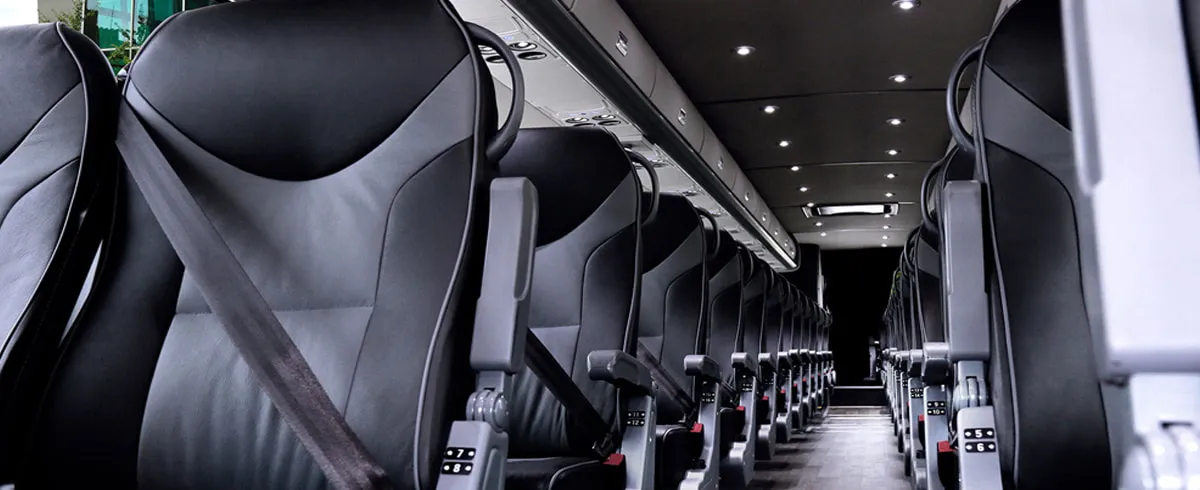 Motor Coach VIP (Leather Seats) interior with passenger seat belts and overhead parcel racks for charter bus rental