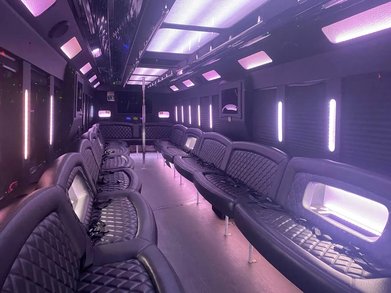 25 Passenger Party Bus interior with perimeter lounge seating, LED accent lighting and LED ceiling lighting for party bus rental