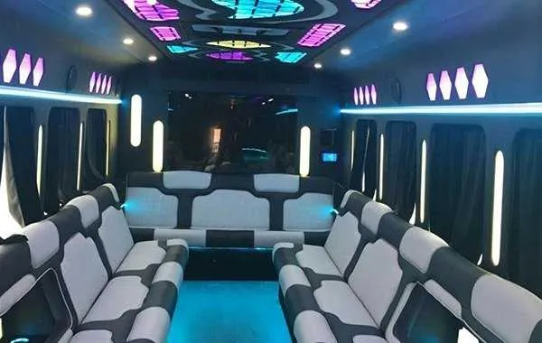Party Bus White Party Bus White cabin – perimeter lounge seating, window shades and LED accent lighting