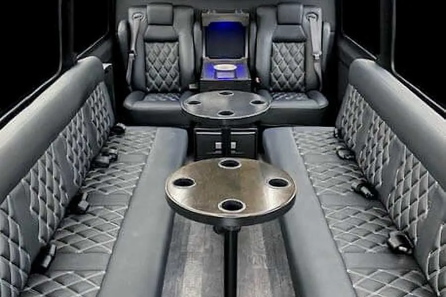 Sprinter Van- 12 Pax interior with perimeter lounge seating, captain's chairs and passenger tables for party bus rental