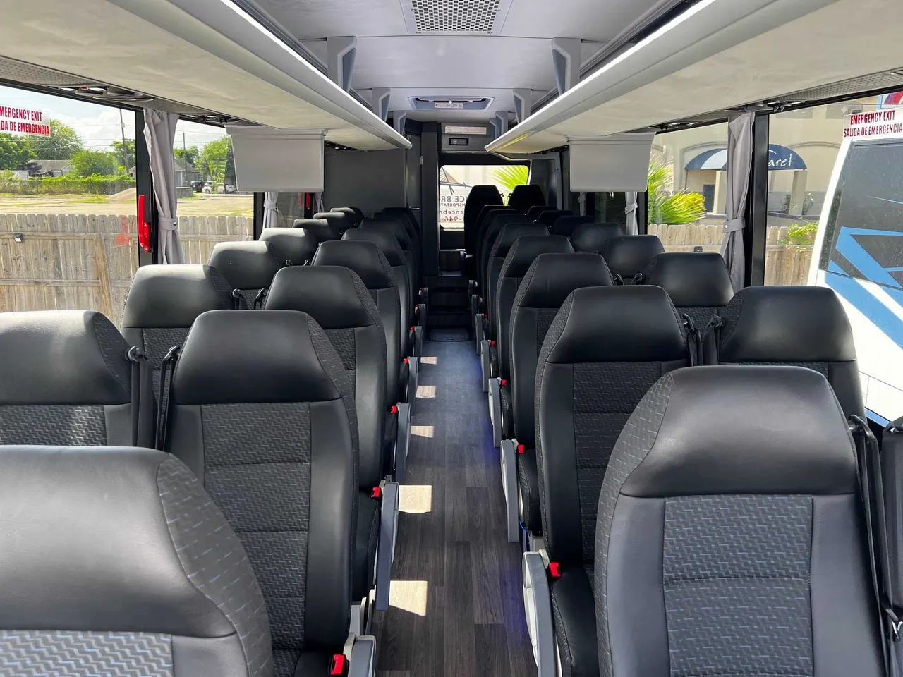 Motorcoach interior with window shades and overhead parcel racks for charter bus rental